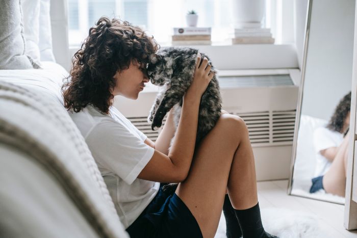 Frau mit Katze im Schlafzimmer